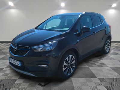 a black opel parked on a checkered floor in a garage