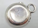 a silver pocket watch that is on a table