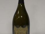 une vieille bouteille de champagne posée sur une surface blanche