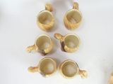 five cups and a spoon sitting on a table