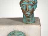 an image of a sculpture of a woman ' s head on a marble block