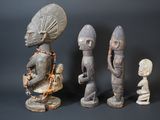 three wooden figurines of different shapes and sizes on a black background