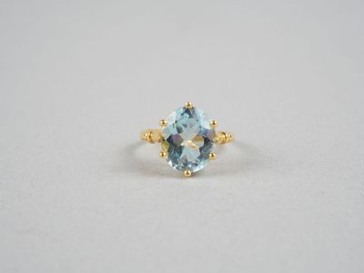 une bague en topaze bleue avec un anneau en or et une pierre de topaze bleue
