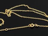 a close up of a gold chain on a black surface