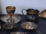 a black table with silver dishes and silver cups on it