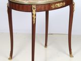 une photo d'une petite table au plateau en marbre posée sur un sol blanc