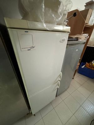 un réfrigérateur blanc et un réfrigérateur argenté dans une pièce