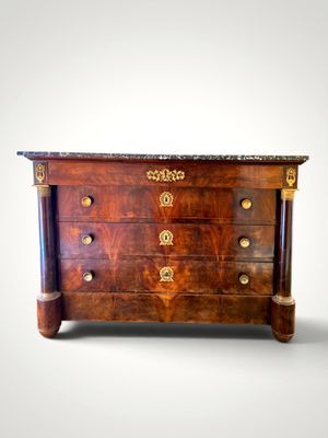 a small wooden chest of drawers with marble top