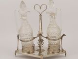 two glass vases on a metal stand with a heart shaped handle