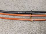 two swords that are laying on the ground