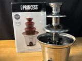 une fontaine à chocolat avec une boîte de chocolats sur la table