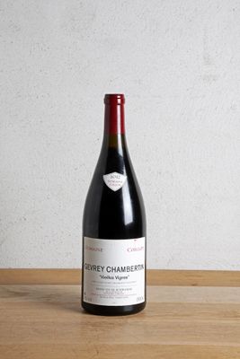 une bouteille de vin rouge posée sur une table en bois