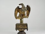 statue en bronze représentant un aigle sur un socle, sur fond blanc