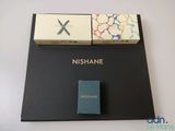 deux boîtes de nishane posées sur une table, à côté d'une boîte d'allumettes