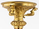 a gold vase with two birds on the top of it