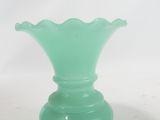 a green glass vase sitting on top of a table