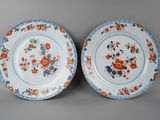 deux assiettes ornées de fleurs orange et bleues sur un fond gris