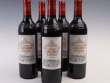 quatre bouteilles de vin sont alignées sur une surface blanche