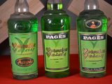 three bottles of green liquid sitting next to each other on a table