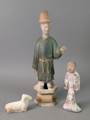 trois figurines représentant un homme coiffé d'un chapeau et un chien