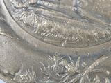 a silver plate with a picture of a man and a dog on it