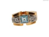 gros plan d'une bague avec une pierre bleue et des diamants