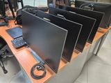 a desk with three monitors and a keyboard on it