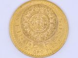 a gold coin on a white surface with a white background