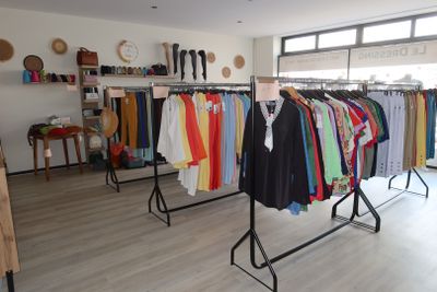 a lot of clothes hanging on a rack in a room