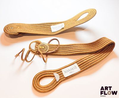 deux cordes marron sont attachées l'une à l'autre sur une surface blanche