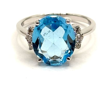 une image représentant une bague en topaze bleue sertie de diamants, sur fond blanc