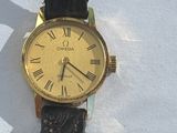 a gold watch with roman numerals on a black strap