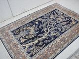 une image représentant un tapis bleu orné d'un motif représentant l'arbre de vie
