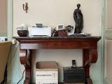 une petite table sur laquelle se trouve une horloge, dans une pièce