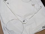 a white t - shirt with a design on it sitting on a cardboard box