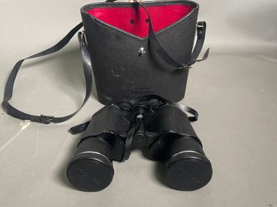 un sac noir avec une poche rouge et une paire de jumelles