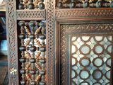 an old wooden cabinet with a mirror and a bunch of beads on it