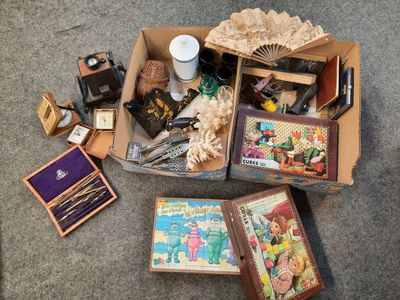 une boîte remplie de livres et d'autres objets posée par terre