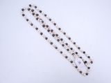 a close up of a white and black beaded necklace on a white surface