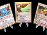 Trois cartes Pokémon sont représentées en rangée sur un fond noir