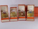 four small orange boxes with perfume bottles in them on a white surface