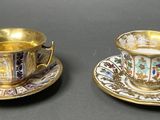 two cups and saucers are sitting on a table