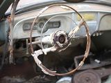 steering wheel and dashboard of an old car with rust on it