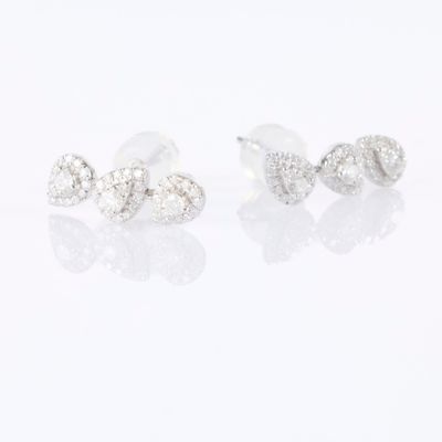 une paire de boucles d'oreilles en or blanc et diamants sur fond blanc
