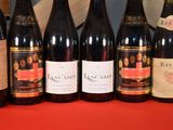 several bottles of wine are lined up on a red table