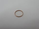a gold wedding ring on a white surface