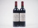 deux bouteilles de vin rouge posées l'une à côté de l'autre sur une surface blanche