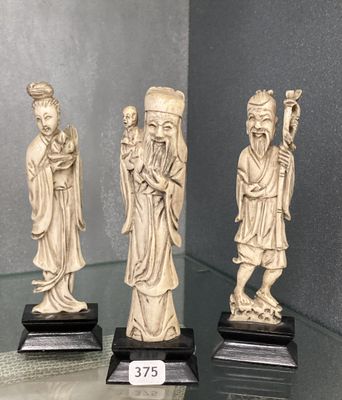 trois figurines chinoises sculptées représentant des hommes et des femmes, exposées