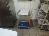 a small kitchen with a metal cart in the middle of the floor