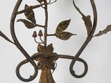 wrought iron wall sconce with flowers and leaves on a white background